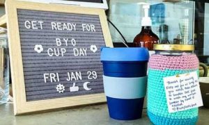 Byo coffee cup and sign to encourage Byo cup day